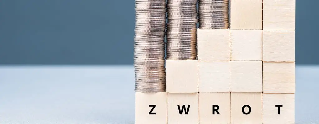 Obrazek wyróżniający w artykule - zwrot dofinansowań pfron. Na obrazku widzimy cztery stosy srebrnych monet układających się na drewnianych kostkach z literami. Kostki układają się w słowo "ZWROT". Monety są równo ułożone, każda kolumna na jednej kostce, co daje efekt wielkości zwrotu. Kompozycja obrazu symbolizuje zwrot dofinansowania. Proste przedstawienie sugeruje klarowność przepisów w procesie zwrotu środków.